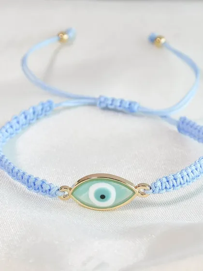 A close-up of one of my braided evil eye rakhis in a beautiful pastel blue. It's a modern take on a traditional symbol.