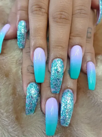 A mermaid-inspired set featuring a turquoise and lavender ombre with chunky turquoise glitter accent nails.