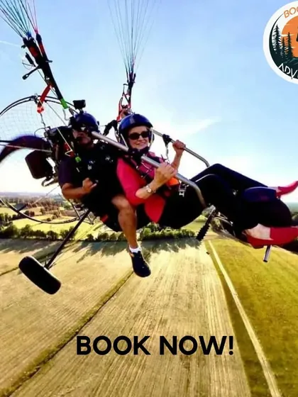 A great shot of our customers enjoying the view from a tandem paramotor. You can see the vast fields below as they cruise through the air, making for a perfect photo opportunity and a lasting memory.
