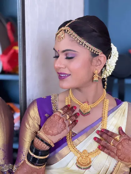 A close-up of the bride's makeup and henna. The purple eyeshadow is blended perfectly for a soft yet glamorous look.