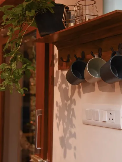 This handcrafted teak wood key holder is a perfect blend of style and function. It features hooks for keys and mugs, plus a small shelf for plants or mail, bringing warmth to your entryway.