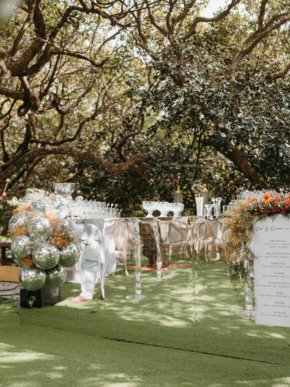 The garden bar setup, featuring a clear acrylic bar, disco ball accents, and a beautifully designed menu.