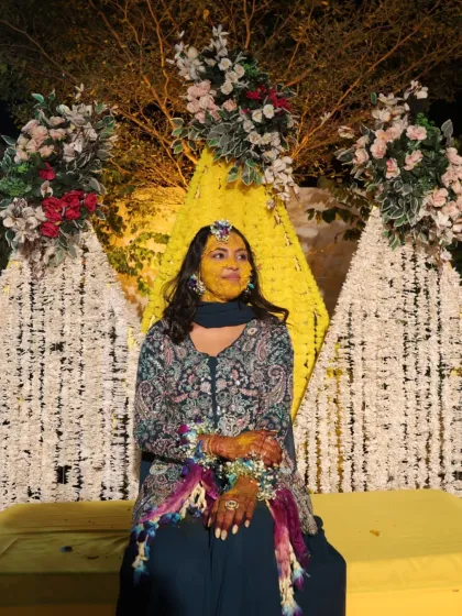 A candid moment from a Haldi ceremony. Even with haldi on her face, the bride's makeup underneath is set to last, and her floral jewelry looks beautiful.