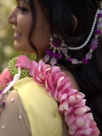 A close-up of the intricate hair accessory we created for this bride's Haldi. It features purple flowers and pearls, designed to be worn with a half-up hairstyle.