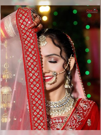 An artistic shot of the bride with her eyes closed, partially covered by her veil, highlighting her makeup and serene expression.
