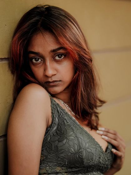 An intense and moody close-up portrait. The direct eye contact and the warm, dramatic lighting create a very powerful image.