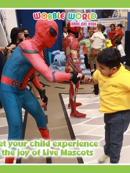 A child shakes hands with Spiderman. Our live mascots provide a joyful and interactive experience for all the kids.