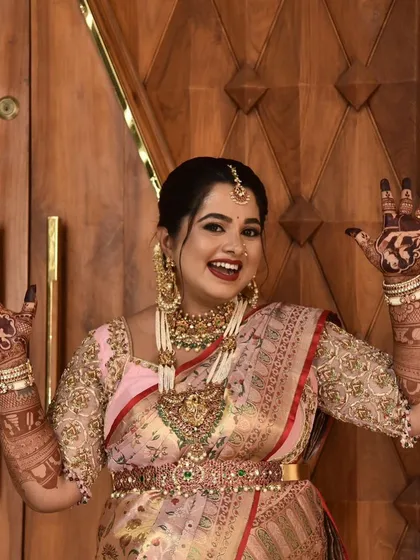 An expressive and happy mom-to-be showing off her custom henna designs. The portraits on her palms are a unique way to celebrate her journey to motherhood.