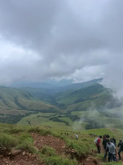 A line of our trekkers making their way up the winding path towards the Kudremukha summit, surrounded by breathtaking valleys.