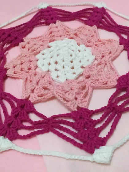 A close-up view of the center of the Karamella doily, highlighting the detailed stitch work and color changes.