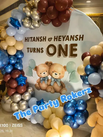 The main backdrop for the twins' teddy bear-themed first birthday, featuring a custom print and a beautiful balloon arch.