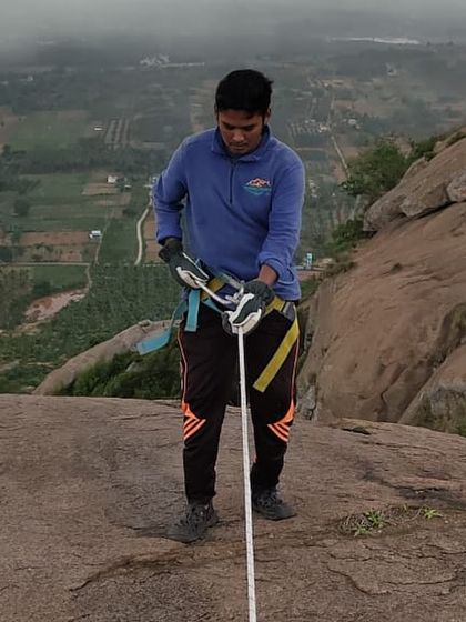 A guide double-checks the harness and equipment before a trekker begins their descent.
