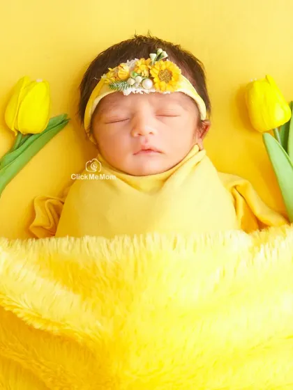 This baby girl is a ray of sunshine, surrounded by yellow tulips and tucked under a soft yellow blanket.