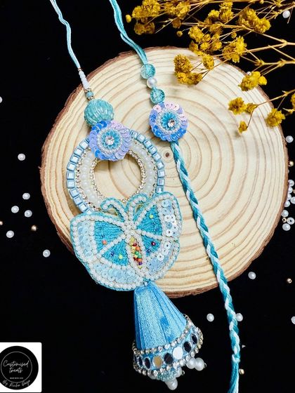 A beautiful butterfly-themed Lumba and rakhi set in shades of blue. The intricate beadwork and sequins make this a dreamy and delicate choice.