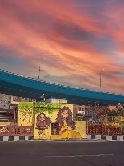 This is my city, Agra. A wide-angle landscape shot capturing the contrast between the modern flyover, local street art, and a dramatic evening sky.