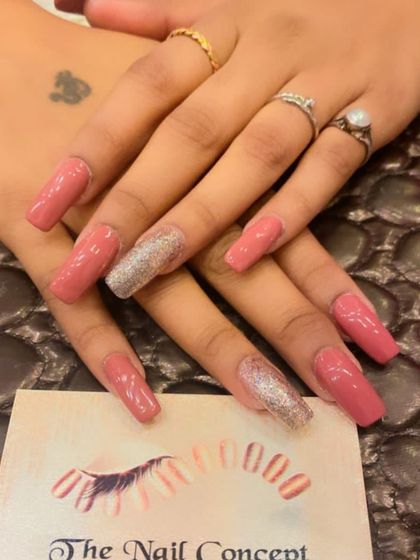 Long, coffin-shaped nails in a soft pink shade. The ring fingers are fully coated in a beautiful silver holographic glitter for a touch of glam.