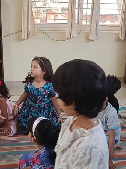 A group of children listens intently, their expressions showing a mix of curiosity and delight.