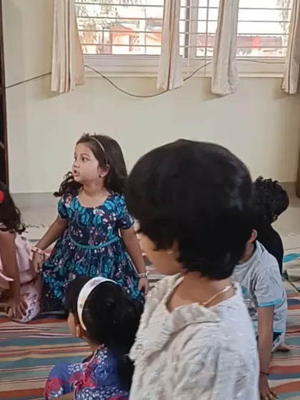 The children's faces are bright with anticipation as they listen to the story.