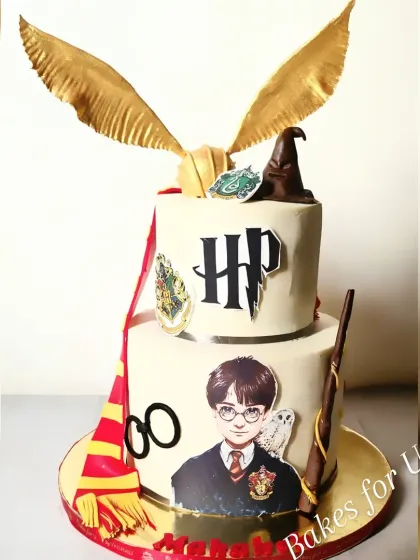 A magical two-tier Harry Potter cake, complete with the Golden Snitch, a sorting hat, a wand, and the Gryffindor scarf. A perfect cake for any Potterhead.