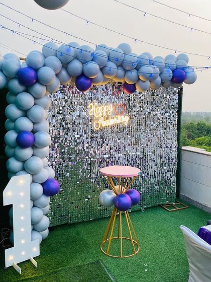 A closer view of the terrace anniversary decor, showing the details of the balloon arch and the shimmering sequin wall.