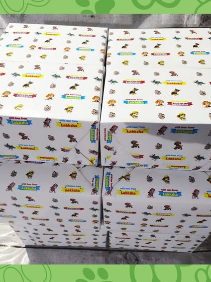 A stack of the Paw Patrol kits, all wrapped in personalized paper for Lakkha's birthday.