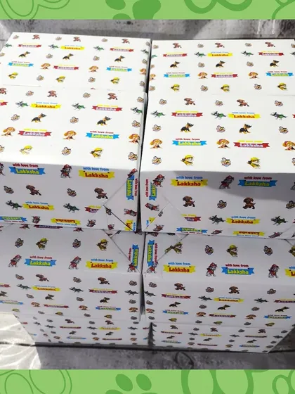 A stack of the Paw Patrol kits, all wrapped in personalized paper for Lakkha's birthday.