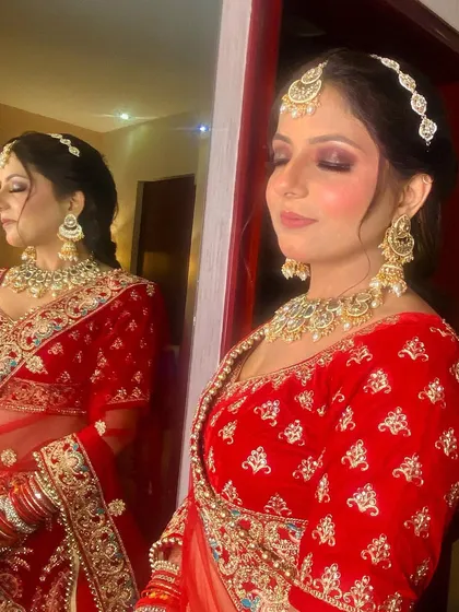 A side profile of a bride, showcasing the beautiful contouring and highlighting that defines her features. The reflection in the mirror adds a lovely artistic touch to the photo.