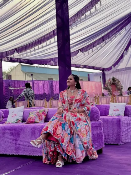 Taking a moment to relax on the plush purple sofas at the Haldi carnival venue.