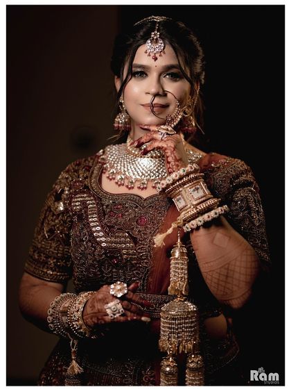 A close-up portrait of the bride, showcasing her intricate nath, kaleerein, and the beautiful details of her bridal jewelry.