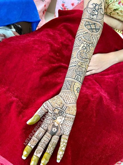 A close-up of the groom portrait on the bride's hand, a beautiful and personal touch to her wedding henna.
