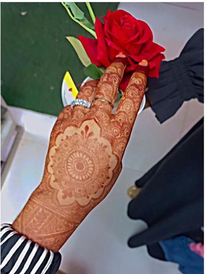 A beautiful stained mandala design, held with a red rose to show the color contrast.