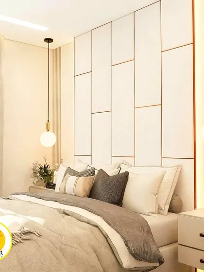 A close-up of the elegant headboard with its geometric paneling and gold trim, flanked by modern pendant lights.