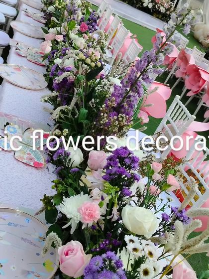 A detailed look at the tablescape for the themed birthday party. The floral runner is a mix of purple, pink, and white flowers, perfectly matching the custom-designed plates.