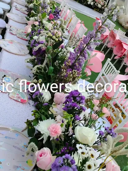 A detailed look at the tablescape for the themed birthday party. The floral runner is a mix of purple, pink, and white flowers, perfectly matching the custom-designed plates.