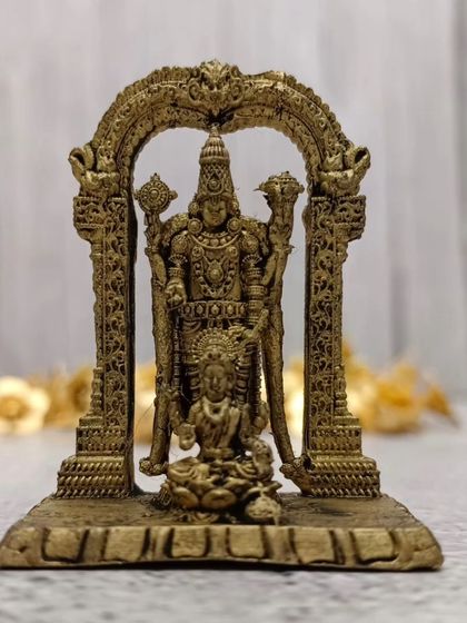 An antique-finished brass idol of Tirumala Balaji Swamy with Goddess Lakshmi seated at his feet, framed by a traditional arch.
