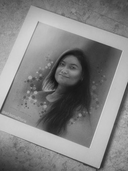 This commissioned portrait was created on toned grey paper, using charcoal and white highlights to create a modern, artistic feel with a bokeh background.