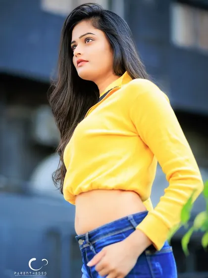 A stylish profile shot that showcases the cropped top and her confident posture.