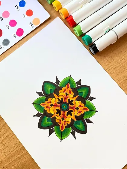 A simple colored mandala with a focus on green and yellow tones. This piece was created with alcohol markers on thick acrylic paper, allowing for smooth color blending.