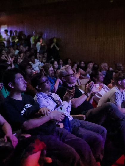 A wide shot of our packed auditorium during a Fête de la Musique concert. The audience is captivated, showing the popularity and draw of our live music events.