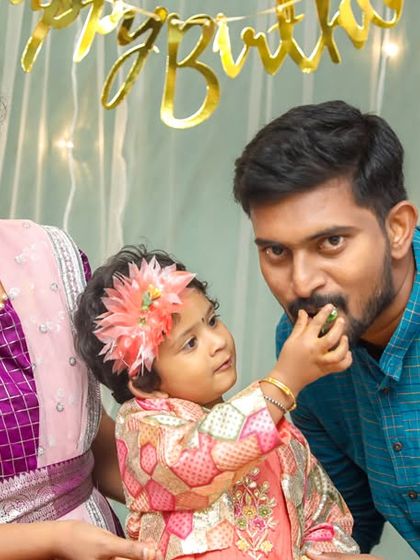A fun and candid moment where the little one is feeding her father a piece of cake.