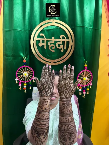 A fun pose from a happy bride, showing the back of her hands. The design features elephant motifs, a popular choice for bridal mehendi.