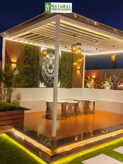 A stunning night view of a pergola in Shahdara, featuring a decorative lion jaali panel, vertical gardens, and elegant pendant lights.