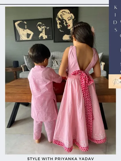 A back view of the coordinated pink sibling set, highlighting the beautiful bow detail on the girl's lehenga. I always add thoughtful details to make each custom outfit feel unique and special from every angle.