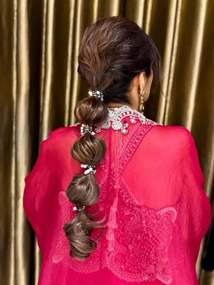 A playful bubble braid ponytail, adorned with small pearl accessories for a touch of elegance.