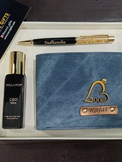 A gift set including a personalized denim wallet, a name pen, and a Bella Vita perfume.