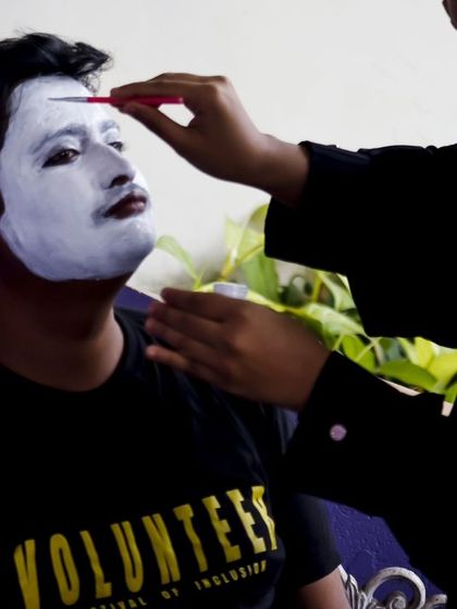 Behind the scenes at Sign Fest. A volunteer carefully applies makeup for a mime performance, a unique art form we use to engage and entertain our diverse audience.