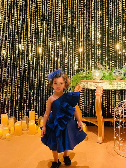 Making a statement in royal blue. This little girl shines against a backdrop of gold in our custom-colored "Desire" dress, proving that a great design looks amazing in any shade.