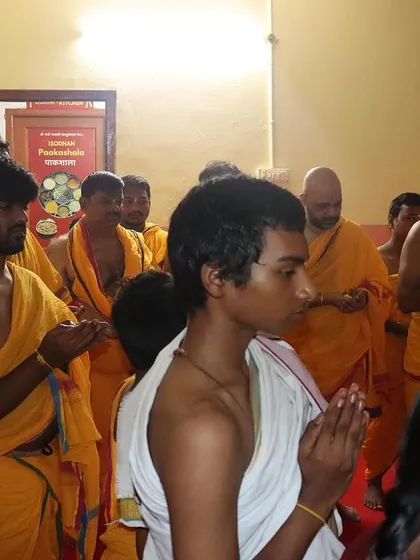 Students stand with hands joined in 'pranam', offering their respects during a morning ceremony. This simple act cultivates humility and an attitude of receptivity to the day's teachings.