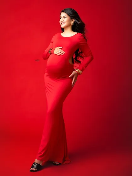 A vision in red. This long-sleeved, open-back gown offers a modern and chic look, perfect for a mamma who wants to show off her confidence.