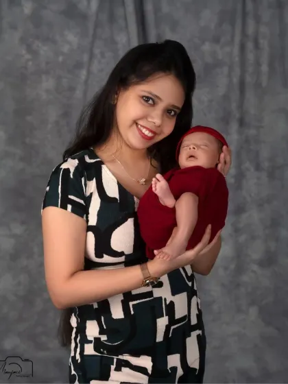 A proud and happy mother holding her precious newborn. Her smile radiates pure joy.